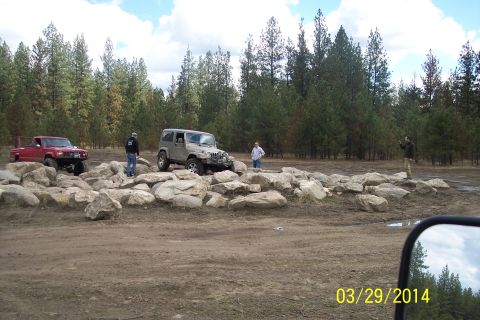 1990 Ford Bronco - Off-roading scene with two vehicles navigating a challenging rocky terrain.