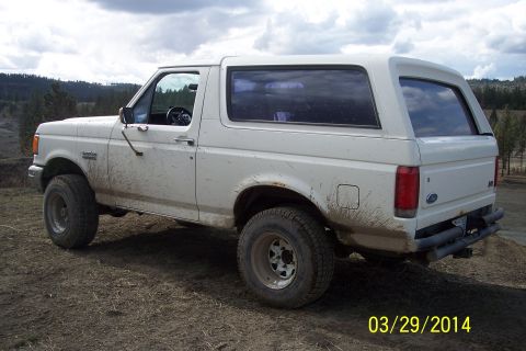 1990 Ford Bronco - White 1990 Ford Bronco parked on dirt with muddy tires and body panels.