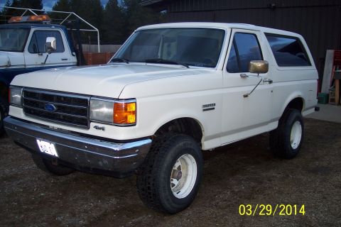 1990 Ford Bronco - This white 1990 Ford Bronco is shown in a 3q-front view, with '4x4' visible on the fender.