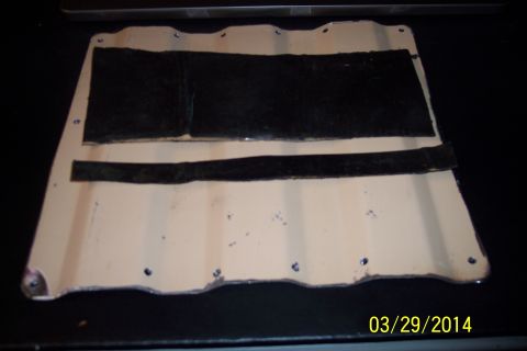 1990 Ford Bronco - A beige metal panel with black strips and screw holes is shown.