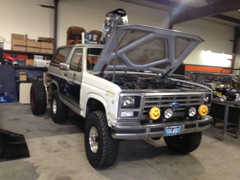 1986 Ford Bronco - This 1986 Ford Bronco is shown with its hood open and two distinctive smiley face lights mounted on the front bumper.