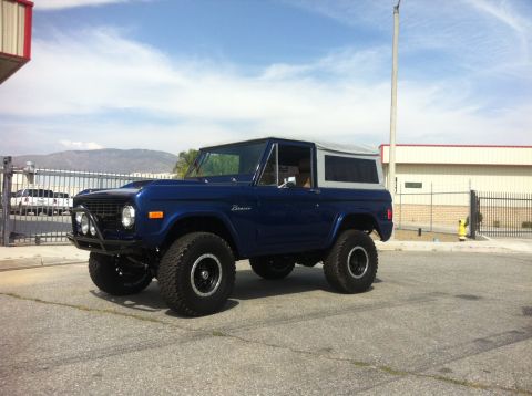 1986 Ford Bronco - This blue 1986 Ford Bronco features a soft top and an aftermarket front bumper.