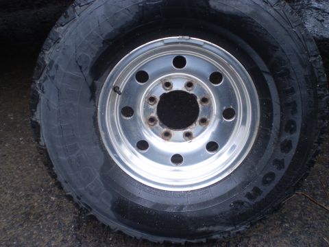 1979 Ford Bronco - A close-up view of a worn tire and its silver alloy wheel.