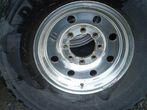 1979 Ford Bronco - A close-up view of a vehicle's aluminum wheel and tire, showing the lug nut holes and tire tread detail.