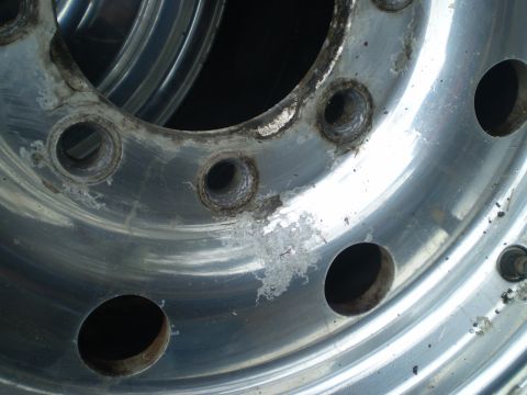 1979 Ford Bronco - Close-up of a corroded aluminum wheel, showing damage around the bolt holes.