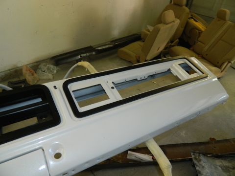 1979 Ford Bronco - Interior parts of a vehicle are laid out in a garage, including a dashboard and seats.