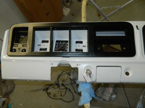 1979 Ford Bronco - The white dashboard instrument cluster features three gauges and a radio slot, with a key in the ignition.