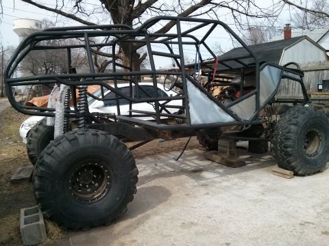 1986 Ford Bronco - This custom-built buggy frame is undergoing modifications and is supported by wooden blocks.