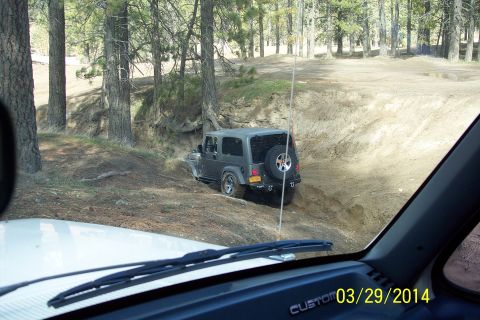 2005 Jeep Wrangler - A dark gray Jeep Wrangler navigates an off-road trail, viewed from the interior of another vehicle.