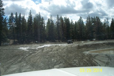 2005 Jeep Wrangler - A Jeep Wrangler navigates a muddy off-road course, with another vehicle visible in the distance.