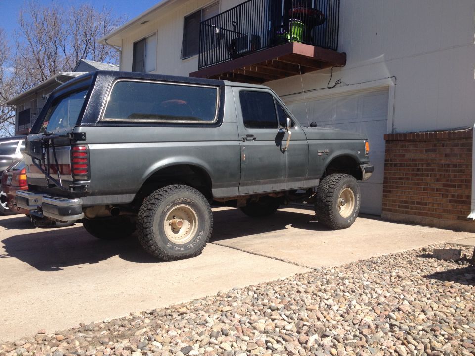 Gray 1990 Ford Bronco side view, lifted with off-road tires