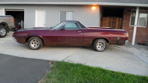 1972 Ford Ranchero - A maroon 1972 Ford Ranchero is parked in front of a house, with a pickup truck visible to its left.