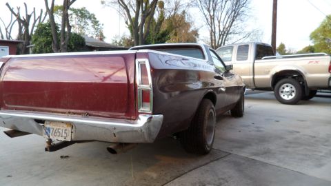 1972 Ford Ranchero - The rear of a classic Ford Ranchero is shown, with a modern pickup truck in the background.