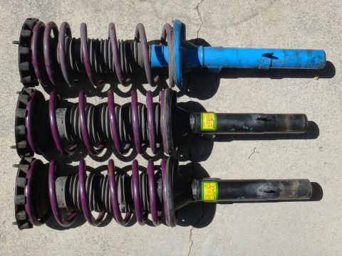 1993 Ford Taurus - Three automotive struts with purple springs and yellow labels are laid out on a concrete surface.