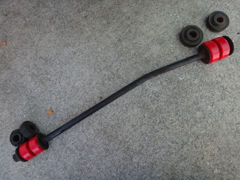 1993 Ford Taurus - Sway bar end link and bushings laid out on a concrete surface.