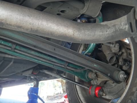 1993 Ford Taurus - Close-up view of the rear suspension system of a vehicle, with a focus on the control arms and sway bar components.