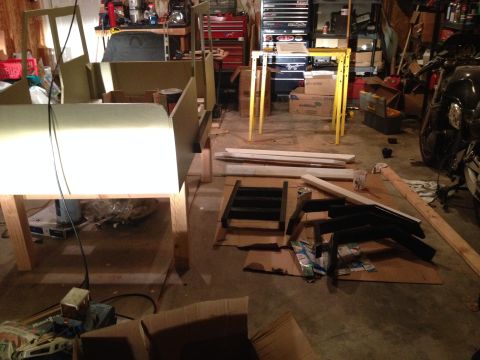 2005 Jeep Wrangler - A partially assembled Jeep body sits in a garage, surrounded by tools and parts.