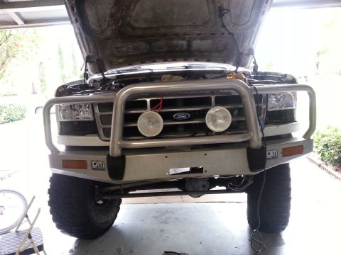 1992 Ford Bronco - The front of a 1992 Ford Bronco is shown with its hood open and a large brush guard installed.