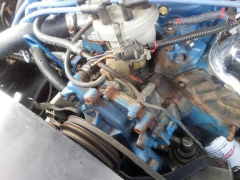 1976 Ford Ranchero - The engine bay shows a blue painted engine block with visible rust and wear on its components.
