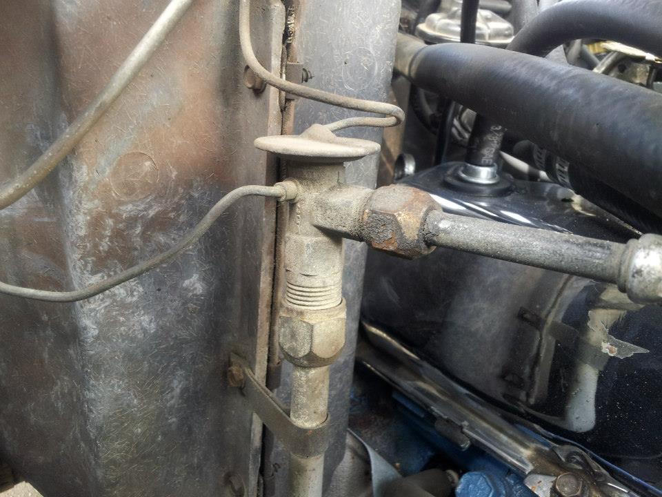 Close-up of an AC expansion valve with metal tubing and hoses