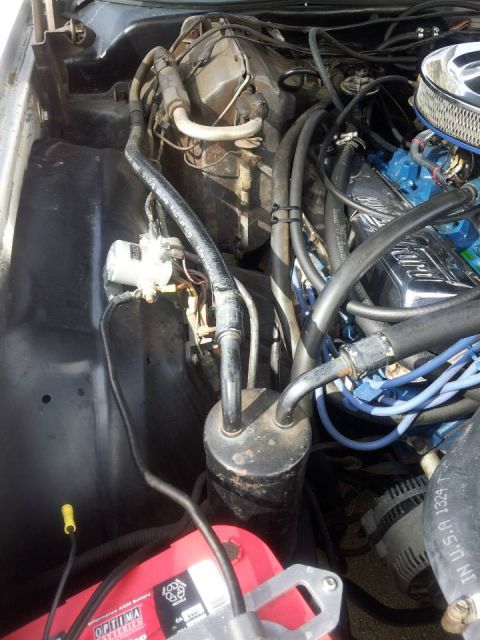 1976 Ford Ranchero - Close-up view of the engine bay, focusing on the air conditioning system's receiver-drier and associated plumbing.