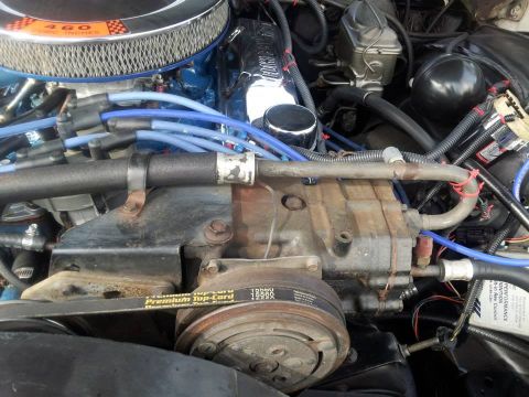 1976 Ford Ranchero - Close-up of an engine bay, focusing on the air conditioning compressor and associated parts.