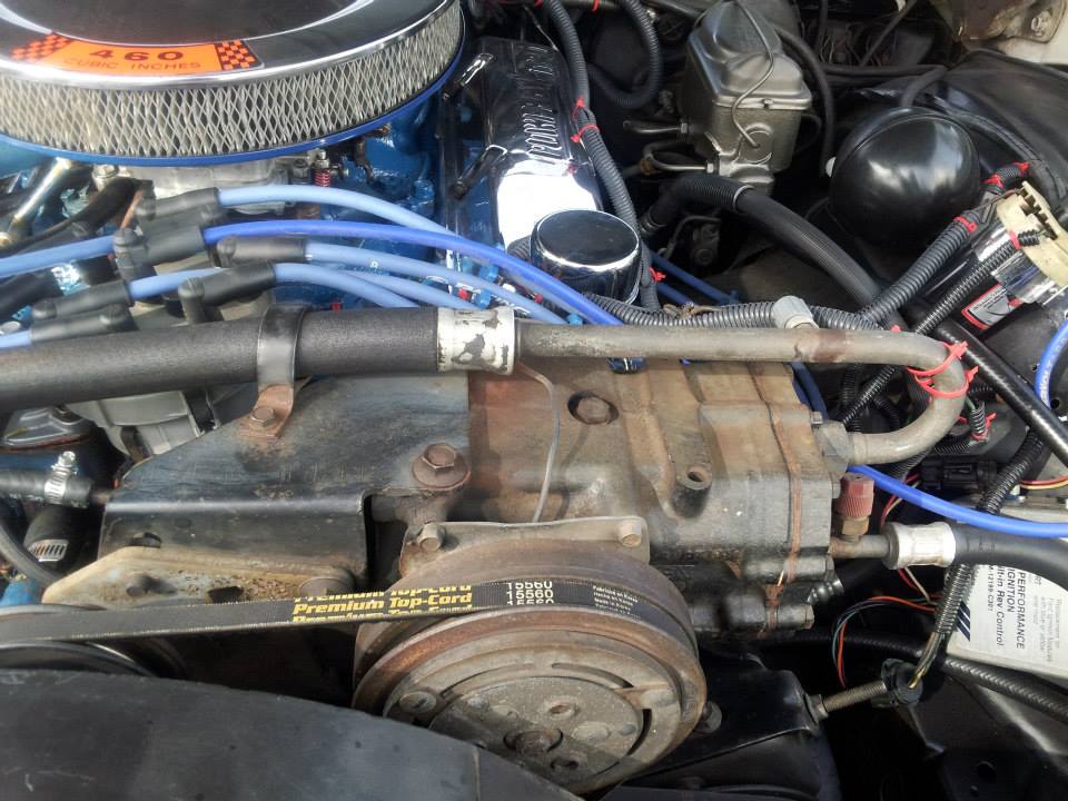 Engine bay detail showing AC compressor, belt, and hoses. Air filter housing reads '460'