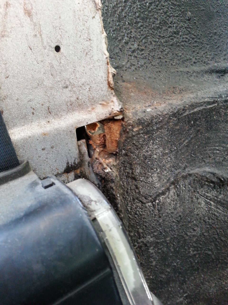 this is a shot of the passenger side from the rear seat near the seat belt. This hole was covered up with some sort of foam from the factory that had started to disintegrate. It's a pretty decent sized hole.