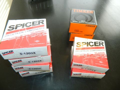 1979 Ford Bronco - Several boxes of Spicer and Timken drivetrain components are arranged on a dark surface.