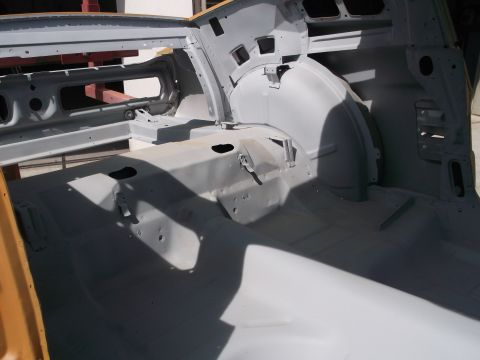 1967 Ford Mustang - The interior of a 1967 Ford Mustang, stripped down and primed for restoration, reveals the floor pan and rear wheel wells.
