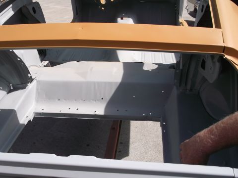 1967 Ford Mustang - Interior of a 1967 Ford Mustang undergoing restoration, showing primer on the floor pan and body panels.