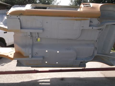 1967 Ford Mustang - Underside of a car body undergoing restoration, showing structural components and floor pan details.