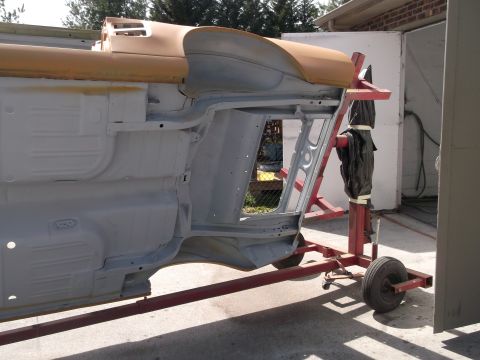 1967 Ford Mustang - The body of a 1967 Ford Mustang is shown on a rotisserie, undergoing restoration with a primer finish.