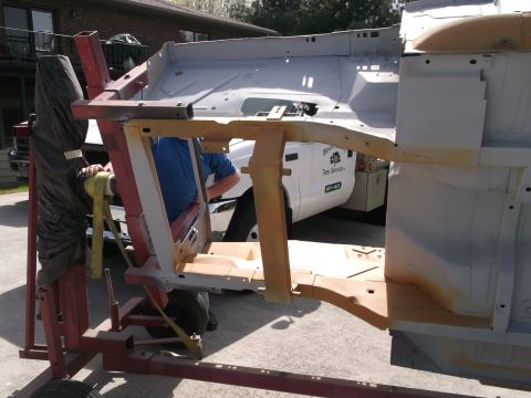1967 Ford Mustang - Car frame being worked on, with a white service truck visible behind it.