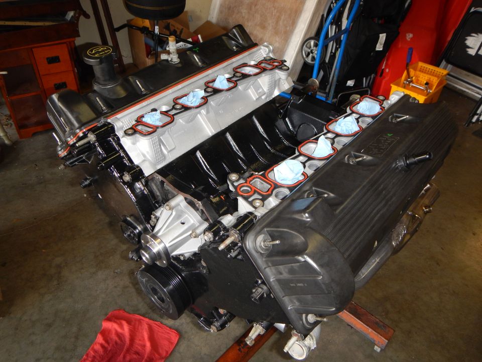 V8 engine block on a stand in a garage with intake ports exposed