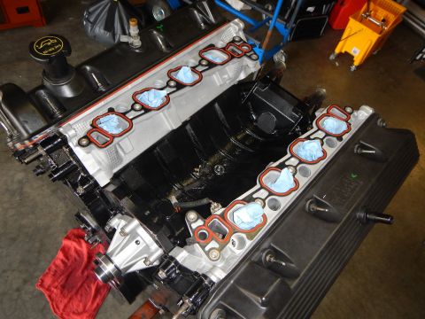 2003 Ford Crown Victoria - Looking down into the open valley of a V8 engine, both cylinder head intake faces sealed with blue tape.
