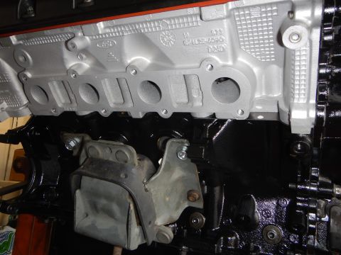 2003 Ford Crown Victoria - Close-up of an aluminum intake manifold's oval ports and cast markings above a painted block and mount bracket.