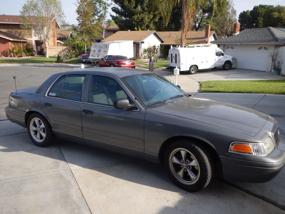 Gray full-size Ford sedan parked front three-quarter view in driveway