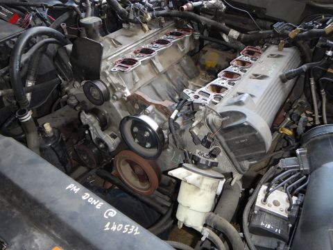 2003 Ford Crown Victoria - Close-up of a disassembled V-engine showing exposed cylinder heads, intake ports, and a pulley, marked PM DONE 140531.