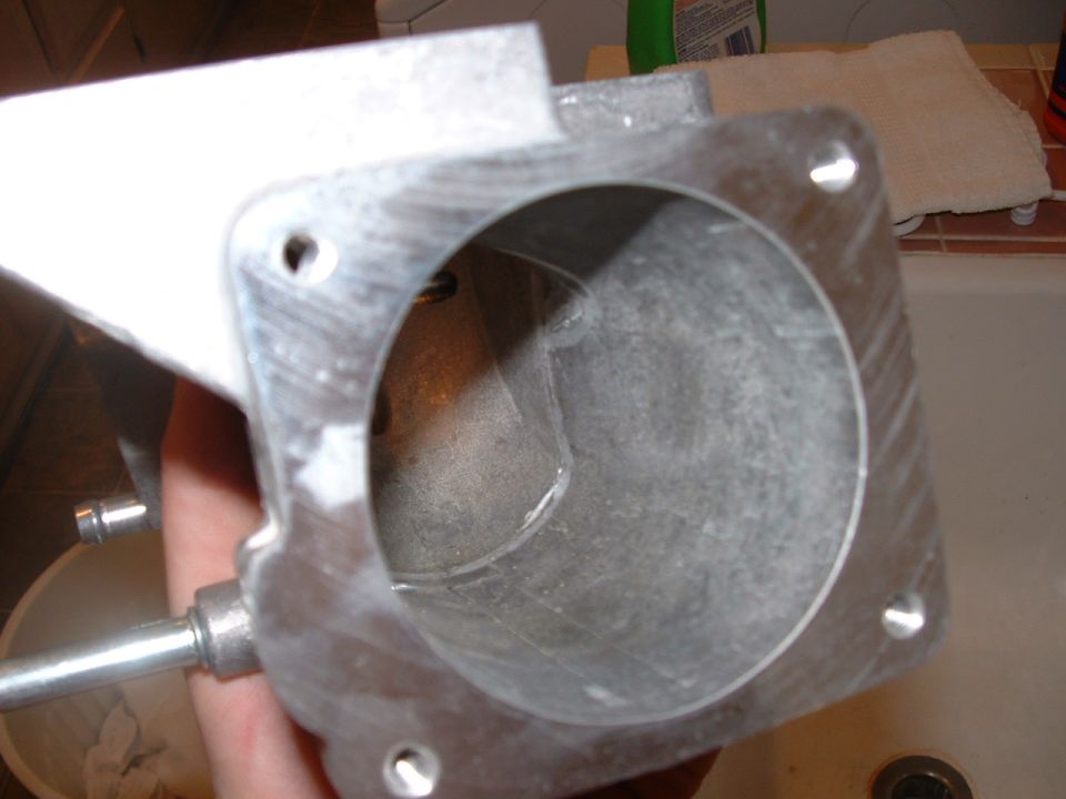 Polished metal exhaust manifold runners bolted to a flange