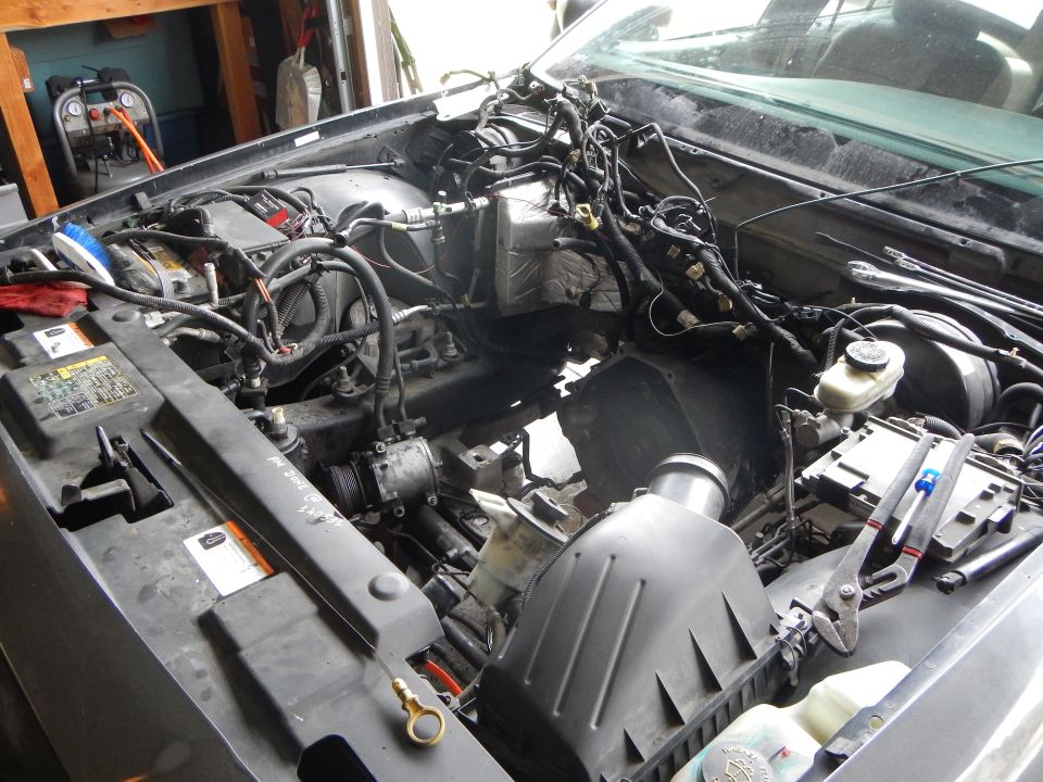 Empty engine bay of a vehicle with wiring harness, brake reservoir and air box exposed