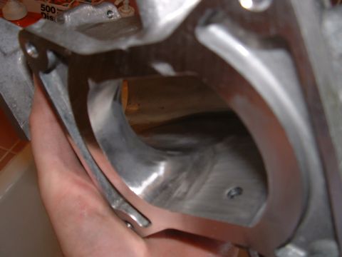1998 Ford Crown Victoria - A metal intake manifold part is held for inspection, revealing its internal structure.