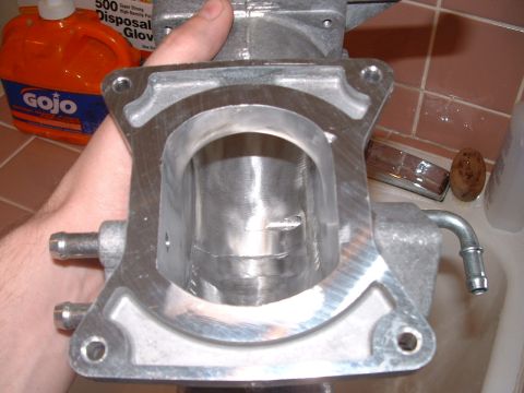 1998 Ford Crown Victoria - Metal throttle body part with hoses, held by a hand. GOJO bottle in background.