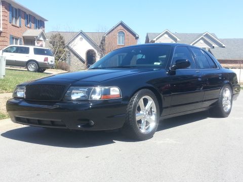 2003 Mercury Marauder - A black 2003 Mercury Marauder is parked on a residential street, with a white SUV visible in the background.