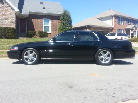 2003 Mercury Marauder - Side profile of a black 2003 Mercury Marauder sedan parked on a residential street.