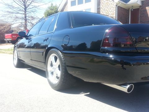 2003 Mercury Marauder - This black sedan features tinted taillights and a polished exhaust pipe, seen from the rear quarter angle.