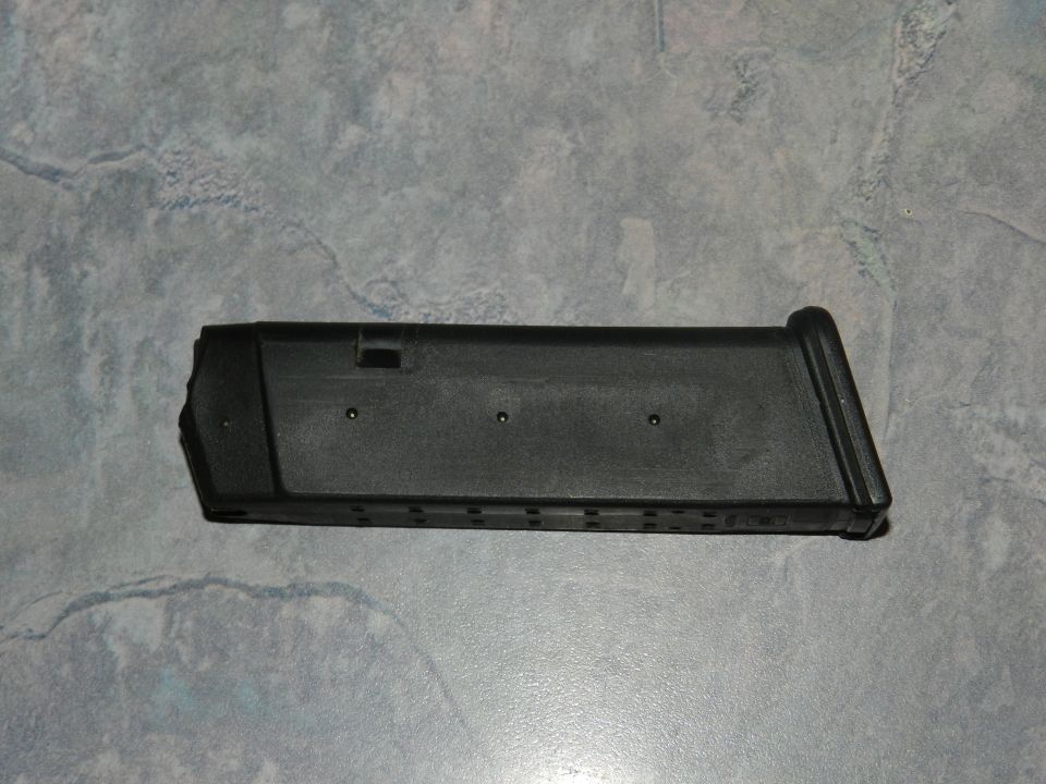 Black gun magazine on a textured gray surface