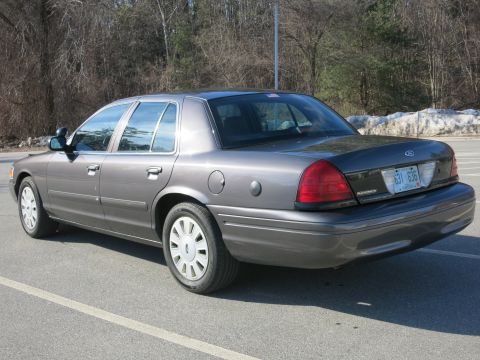 2001 Ford Crown Victoria - This Ford Crown Victoria is seen from the rear-quarter angle, parked outdoors with trees in the background.