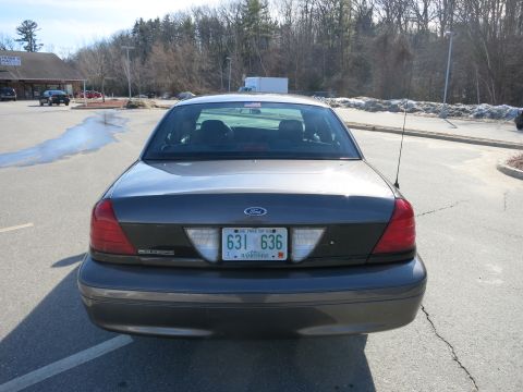 2001 Ford Crown Victoria - Rear view of a dark gray 2001 Ford Crown Victoria, showing its distinctive taillights and license plate.