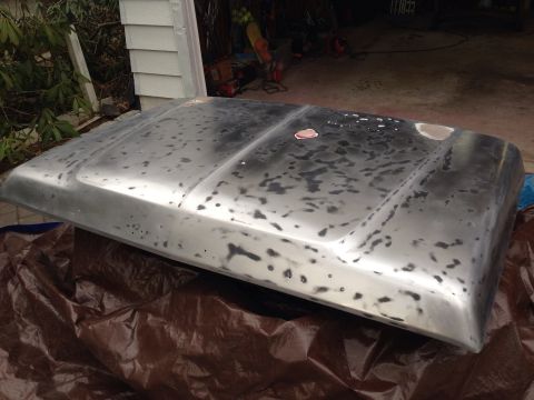 1979 Ford Bronco - Car hood undergoing preparation for paint, showing bare metal and primer patches.